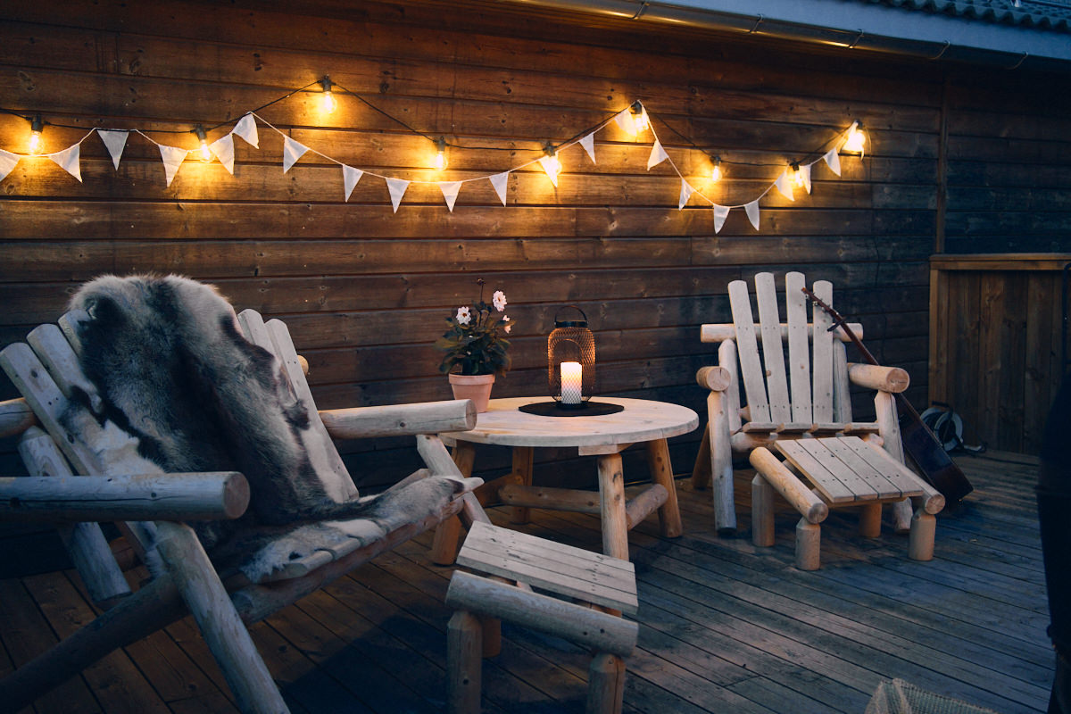 Hagemøbler står ute på terrassen en mørk sommerkveld med lyslenke